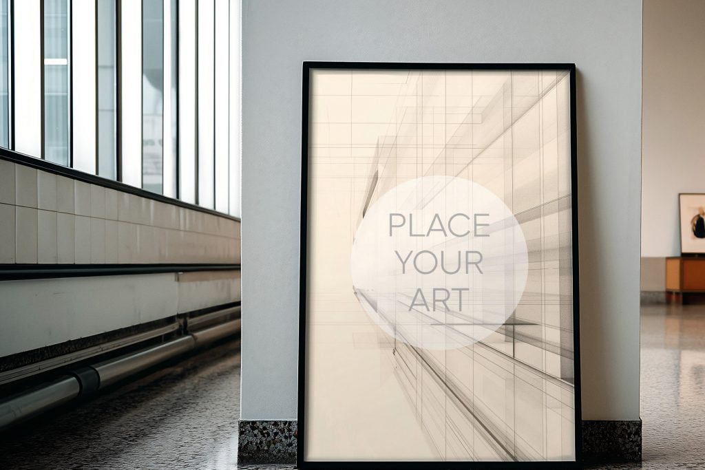 wall-art-frame-mockup-atomic-era-retro-industrial-window-hallway.jpg Vertical black wall art frame mockup leaning against a white pillar in a bright industrial mid-century hallway with large windows and metallic pipes.