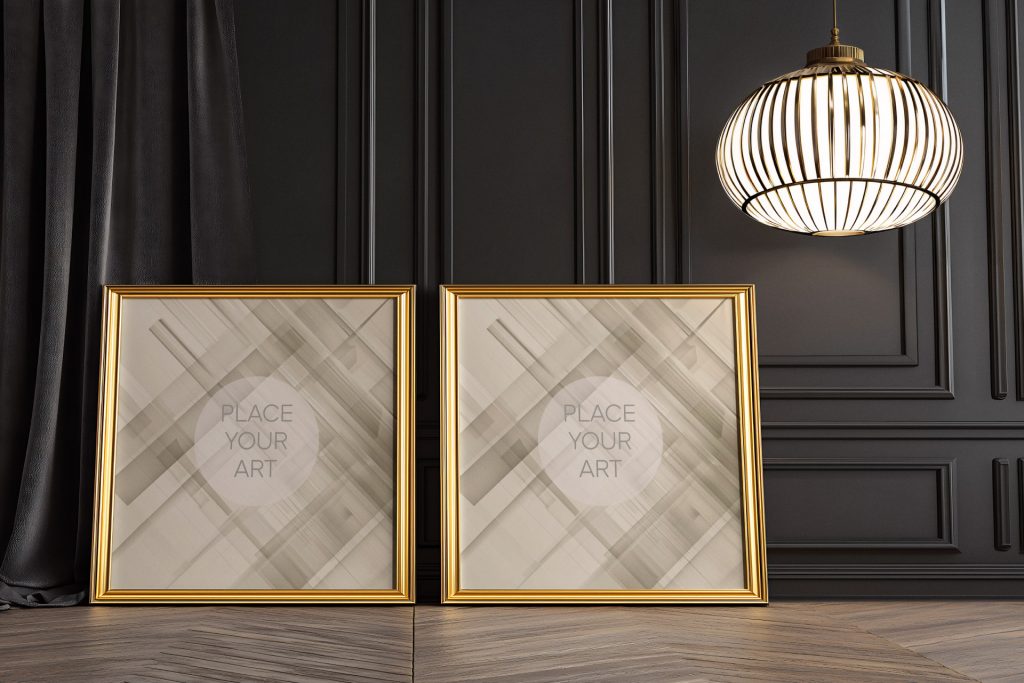 Two square gold ornate frames leaning against a dark wainscoted wall under a glowing Art Deco pendant lamp.