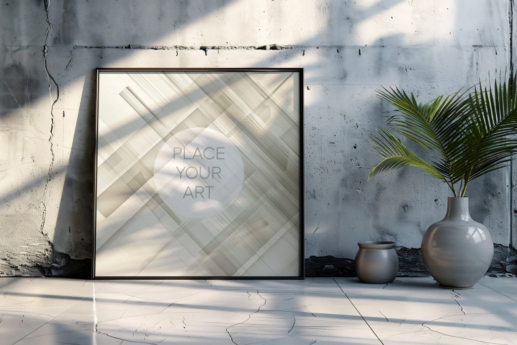Large square wall art mockup leaning on a cracked polished concrete floor against a raw cement studio wall, styled next to a glossy grey ceramic vase with palm leaves under dramatic sunlight shadows.
