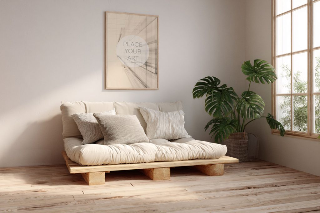 japandi-living-room-mockup-futon-sofa-monstera-plant.jpg Vertical wooden frame mockup hanging above a low beige futon sofa on a wooden pallet frame next to a large Monstera plant.